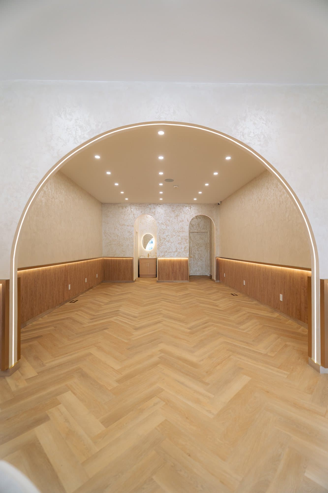 Arched cafe dining room with a reeded oak wainscot and herringbone floor