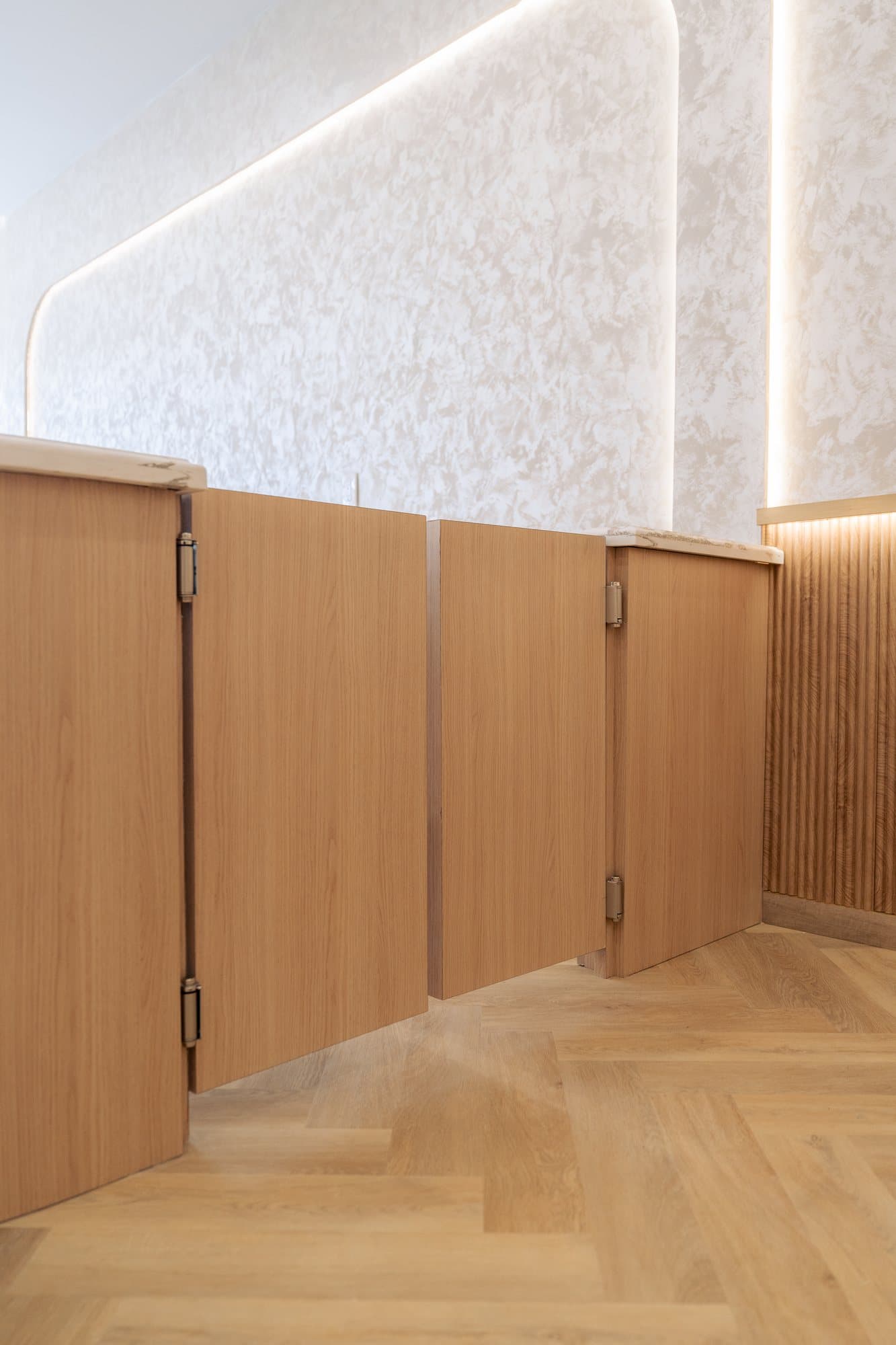 Fluted white oak doors set into a reeded wainscot run