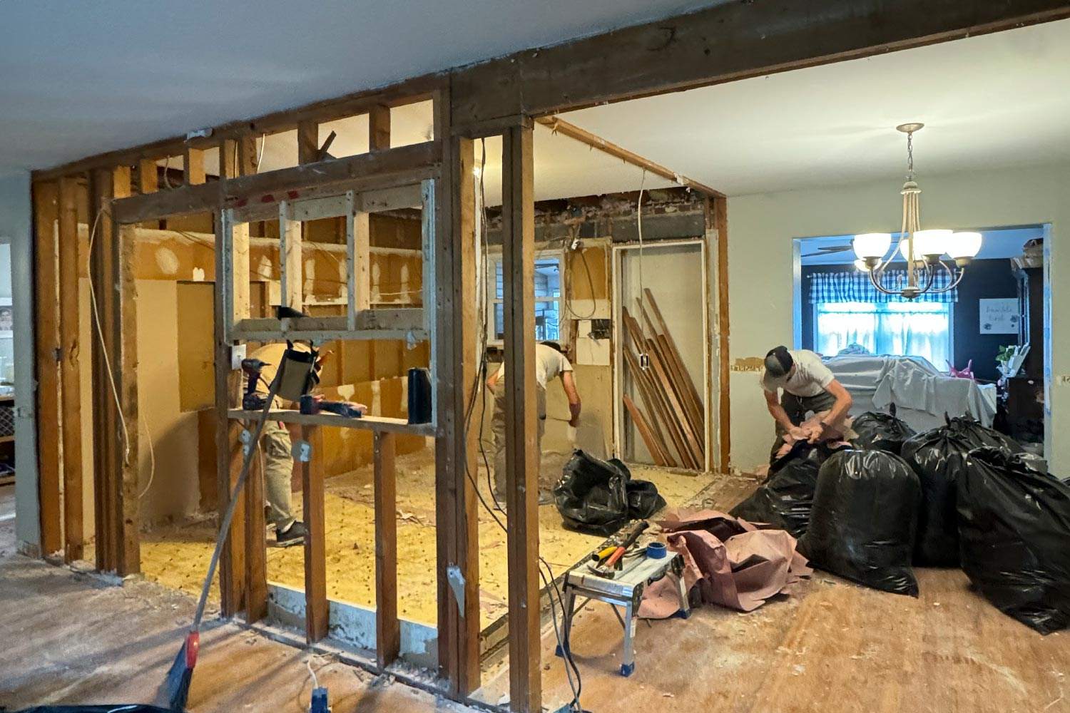 A kitchen stripped back to studs during demolition with the beam being framed in