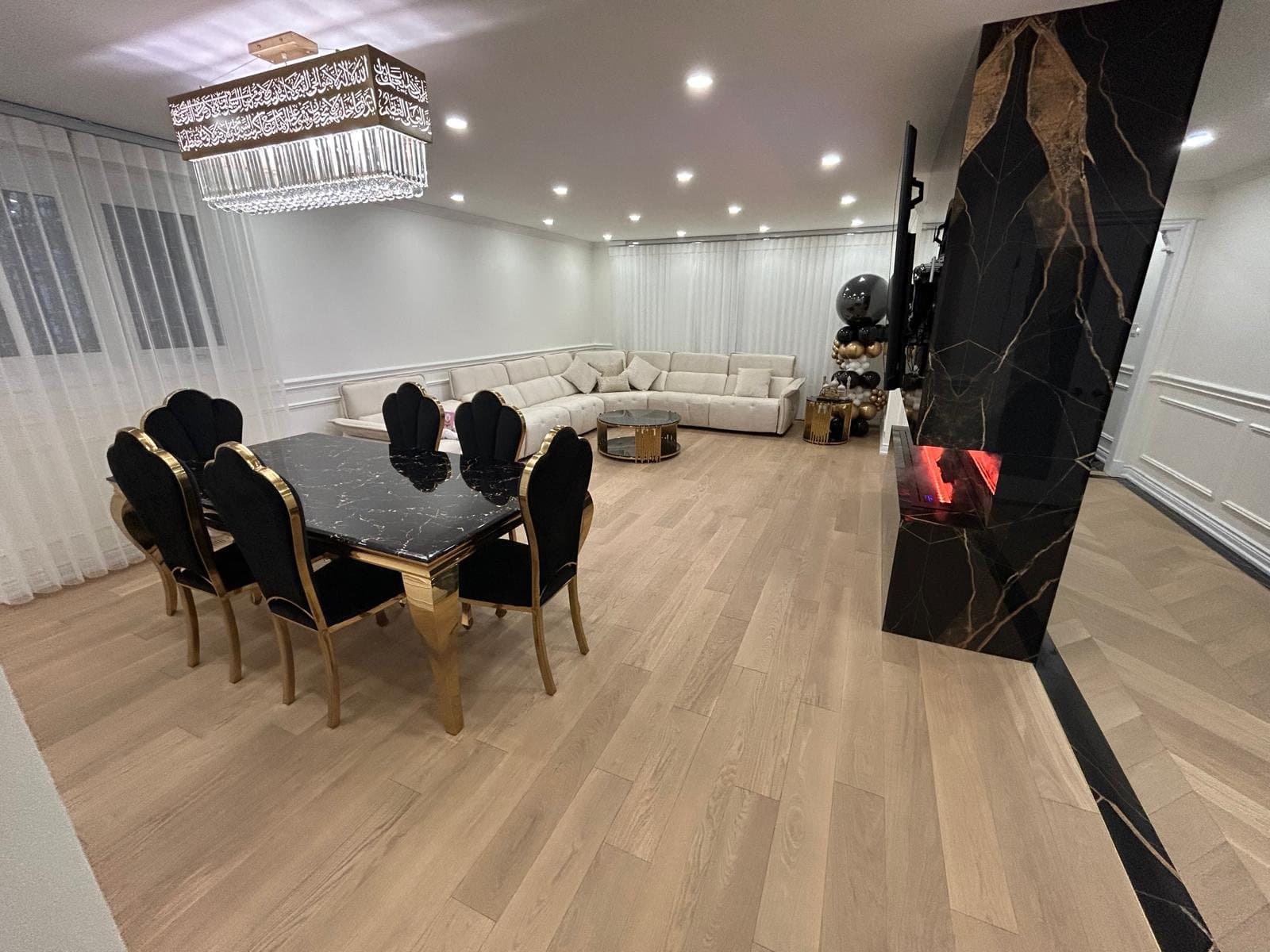 Dining room with a book-matched black marble feature wall and coffered ceiling