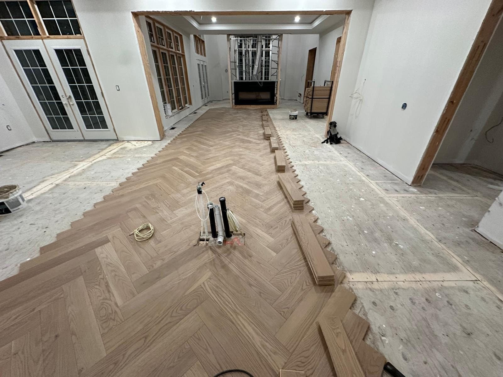 Herringbone oak flooring part-laid across a room during installation