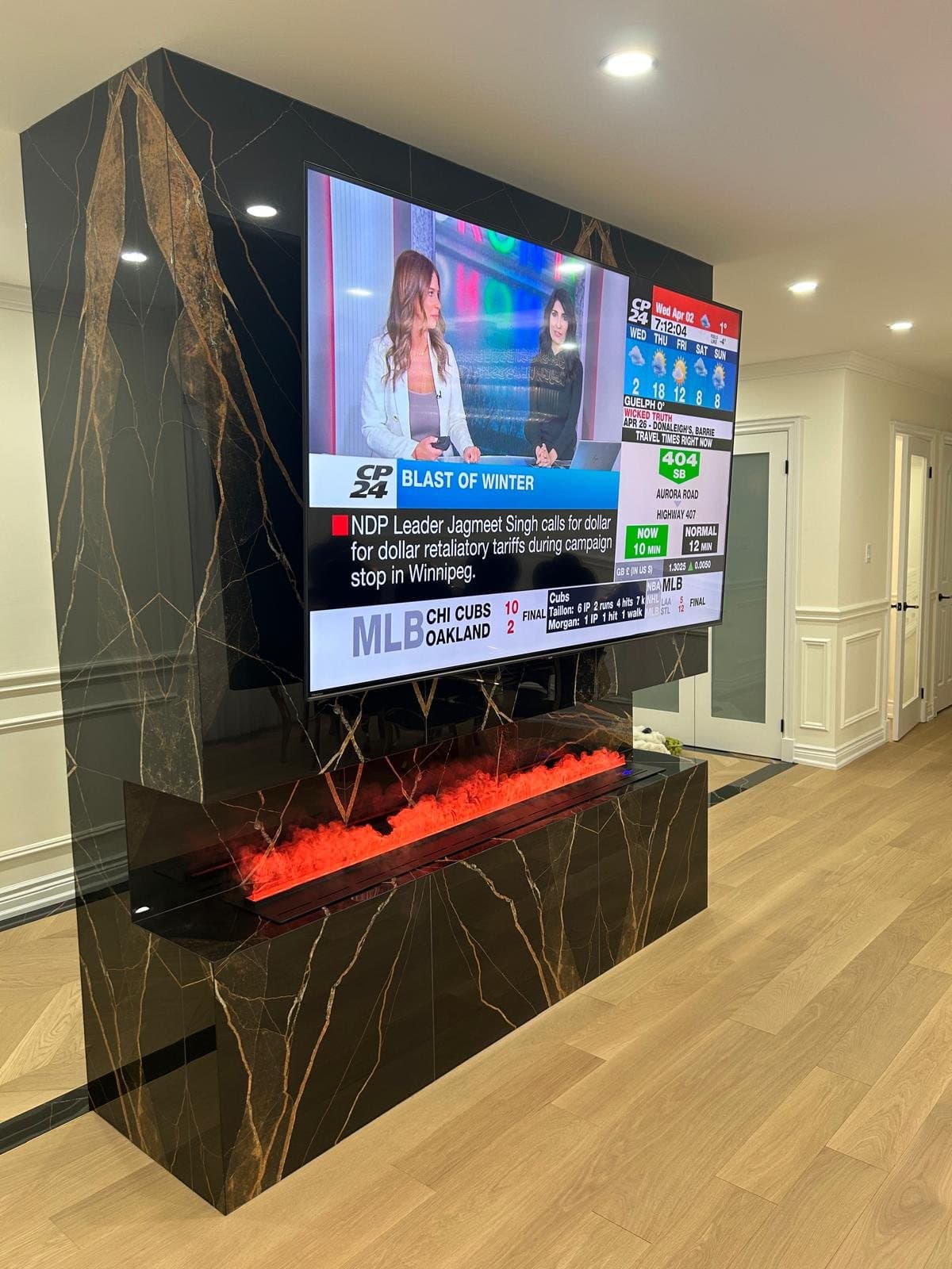 Media wall in book-matched black marble with a linear fireplace below the screen