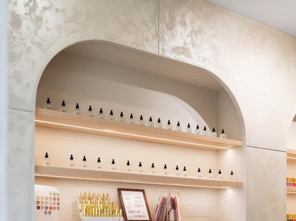 Arched, backlit display niche with product shelving in a salon