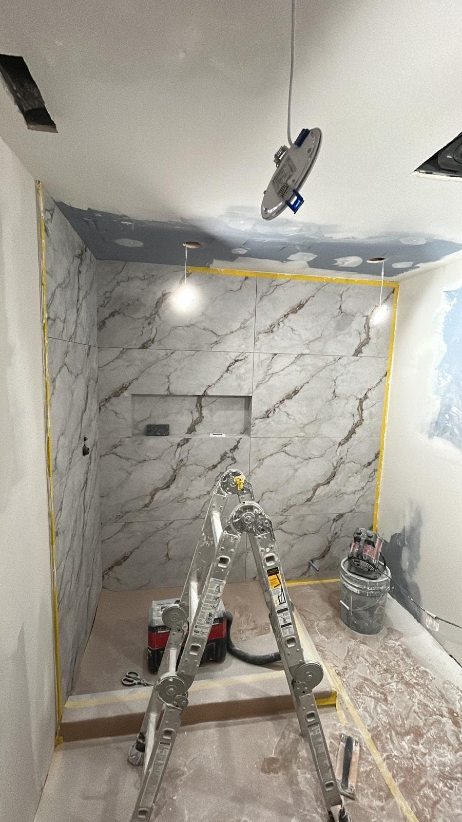Slab shower walls part-installed with the room masked off