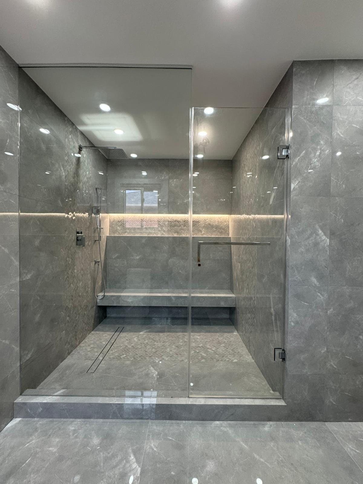 Grey stone double shower with a bench and a full-width lit niche
