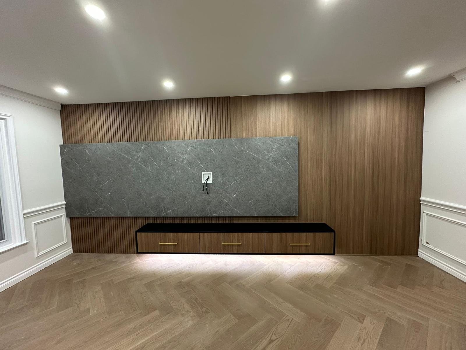Walnut slat feature wall with a stone panel and a floating lit console